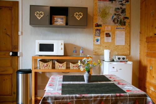 a small kitchen with a table and a microwave at Au Coeur du Lapidaire in Septmoncel