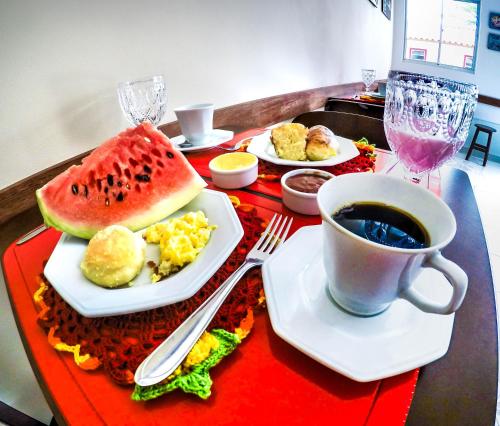 バーハ・グランデにあるMorada das Palmeirasの食べ物の皿とコーヒーカップが置かれたテーブル