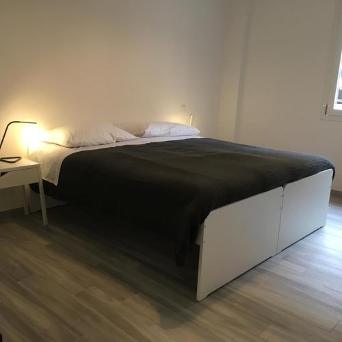 a bedroom with a large bed with a black blanket at Four Rooms in Bologna
