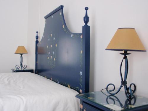 ein Schlafzimmer mit einem Bett und einem Tisch mit einer Lampe in der Unterkunft Alentejano Low Cost Hotel in Estremoz