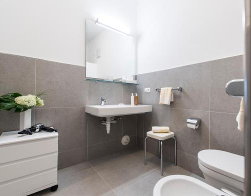 a bathroom with a sink and a toilet and a mirror at Villa Caldarum in Caldaro