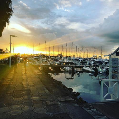 a person walking on a sidewalk near a marina at Goldy House, logement vue mer , jacuzzi 10min port et aéroport in Baimbridge