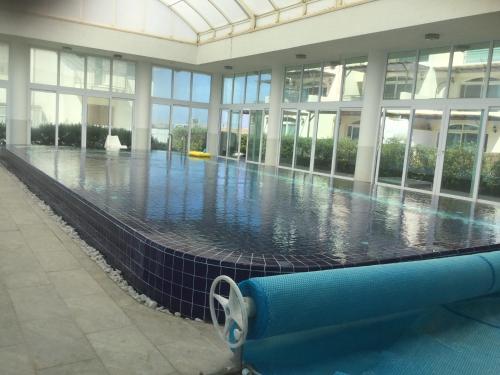 a large swimming pool in a building with a swimming pool at Aphrodite Beachfront Apartment in Ghaziveran