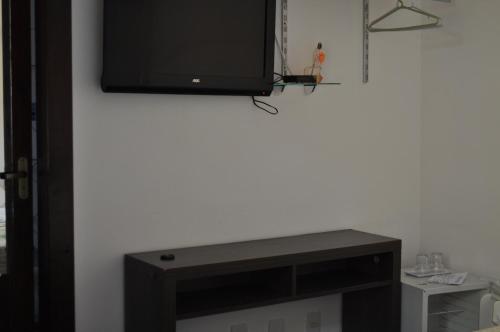TV de pantalla plana colgada en la pared en Pousada Raios do Sol, en Búzios