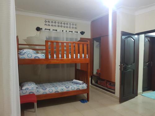 a room with two bunk beds in a room at Family Friendly Stay near Entebbe Airport in Entebbe