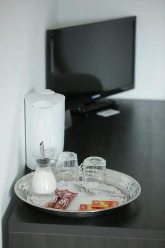 a plate with glasses and a candle on a table at B&B Hotel Telsiai in Telšiai