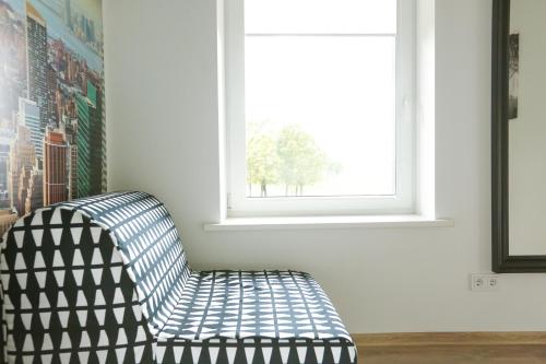 a black and white chair in a room with a window at B&B Hotel Telsiai in Telšiai