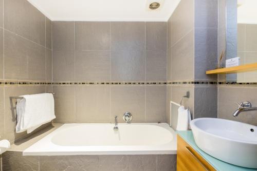 a bathroom with a white tub and a sink at Point Waterfront Apartments in Durban