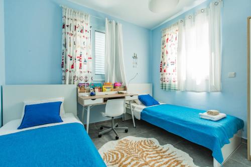 a blue room with two beds and a desk at Blue Diamond Beach Villas in Paphos City