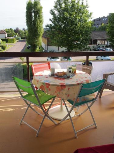 une table et deux chaises assises sur un balcon dans l'établissement Studio-cabine simple et fonctionnel à Houlgate, à Houlgate