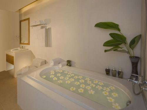 a white bathroom with a bath tub with a plant at Thai House Beach Resort in Lamai