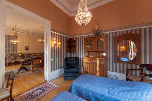 a bedroom with a bed and a living room at Wanha Kartano in Kokkola