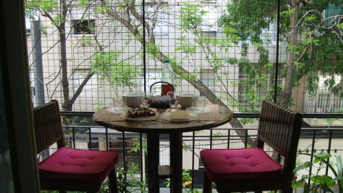 una mesa en un balcón con sillas acolchadas de color rosa en Apartamento en Belgrano C - 2 dormitorios en Buenos Aires