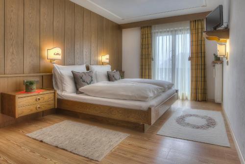 a bedroom with a bed and a television in it at Hotel Luianta in Colfosco