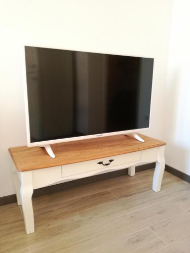 a flat screen tv on a white tv stand at Apartment Lunaja in Piran