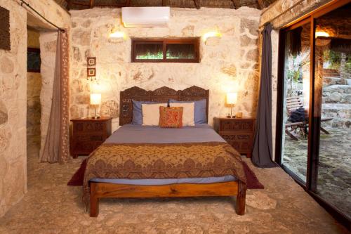 1 dormitorio con 1 cama en una habitación de piedra en Private Bungalow @ Bacalar 7 Colors Lagoon en Bacalar