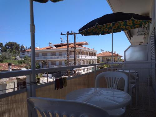 a balcony with a table and an umbrella at Rooms To Let Giannis in Makrýgialos
