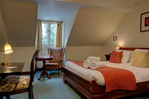 a bedroom with a bed and a desk and a chair at The Grange at Oborne in Sherborne