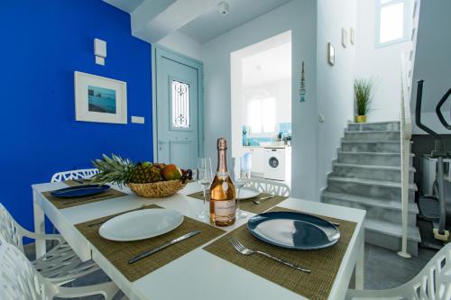 a dining room with a table with a bottle of wine at Blue Diamond Beach Villas in Paphos City