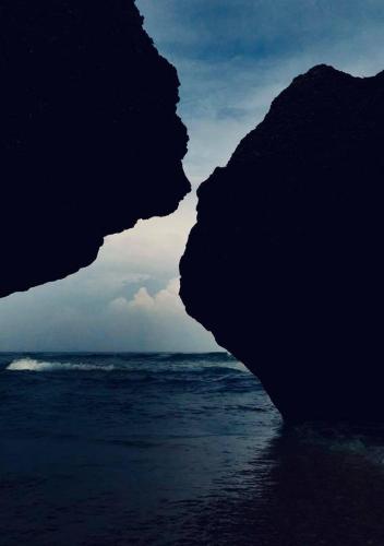 a large rock on the beach next to the ocean at 福緣白龍宮海景 in Xiaoliuqiu
