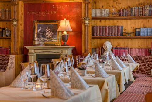 a row of tables in a room with a fireplace at Hotel Restaurant Burg-Klause in Burg auf Fehmarn