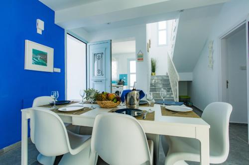 a dining room with blue walls and a white table and chairs at Blue Diamond Beach Villas in Paphos City