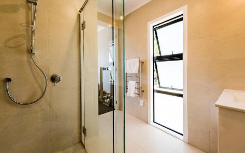 a bathroom with a shower with a glass door at Tui Villa at Putaki Bay in Te Whau Bay