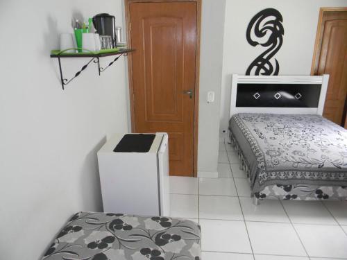 a small room with a bed and a door at Kitnets & Flats in Ubatuba