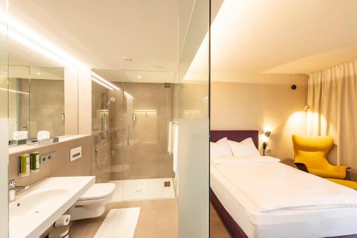 bagno con letto, lavandino e servizi igienici di Hotel Gasthof Fischer a Marchtrenk
