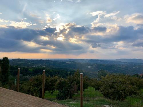 a view of a valley under a cloudy sky at Cascina Filipot in Cerretto Langhe