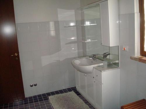 a white bathroom with a sink and a mirror at Al Giardino Degli Etruschi in Chiusi