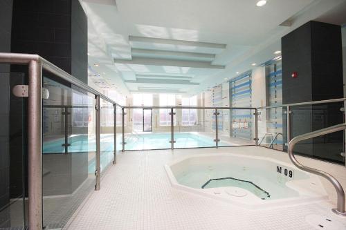 a large bathroom with a tub and a swimming pool at Royal Stays Furnished Apartments - Square One in Mississauga