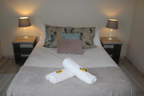 ein Schlafzimmer mit zwei Handtüchern auf einem Bett mit zwei Lampen in der Unterkunft Ley-Lia Guest House in Aranos