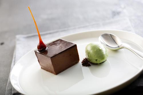 a white plate with a chocolate dessert and a spoon at The Black Bull Inn in Sedbergh