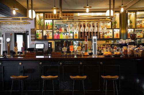 a bar with two bar stools in a room at The Black Bull Inn in Sedbergh