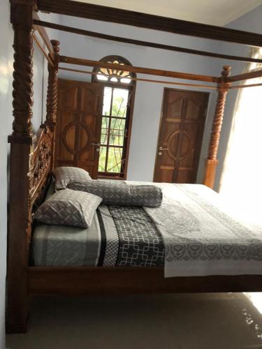 a bedroom with a wooden bed with a mirror at Marie'z Villa in Tuktuk Siadong