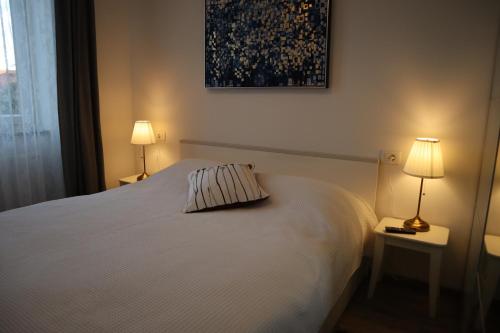ein Schlafzimmer mit einem weißen Bett mit zwei Lampen in der Unterkunft The Luxury Marija Apartment in Zagreb