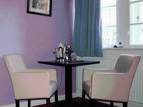 a dining room with a table and two chairs at Apartments im Kaffeehaus Heldt in Eckernförde