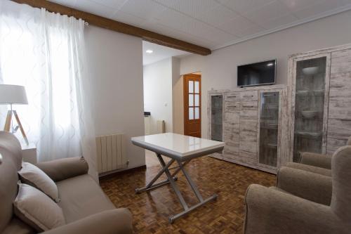 a living room with a table and a tv on a wall at Con encanto y bien ubicado in Logroño