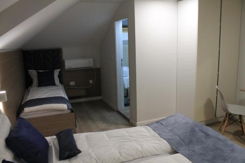 a small bedroom with two beds and a mirror at Sleep Inn Prishtina in Pristina