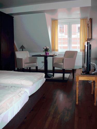 a bedroom with a bed and a table and chairs at Apartments im Kaffeehaus Heldt in Eckernförde