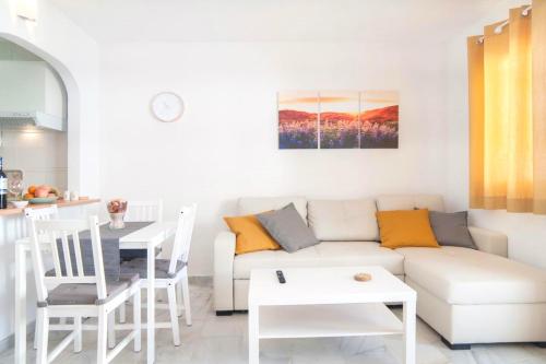 a white living room with a white couch and a table at Happy Nest in Benalmádena