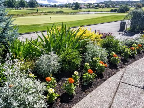 a garden of flowers with a golf course in the background at Resort at Eagle Point Golf Club Lodging in Medford