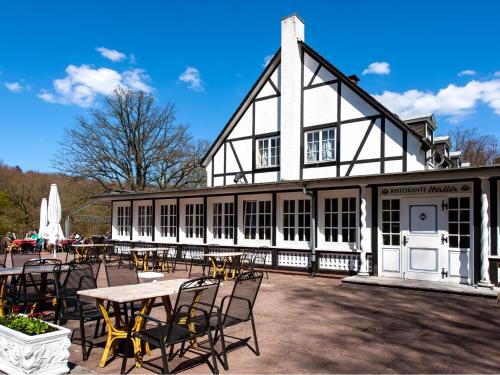 a building with a table and chairs in front of it at Hotel Italia in Aumühle