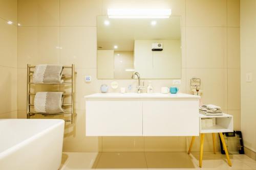 ein weißes Badezimmer mit Waschbecken und Spiegel in der Unterkunft Queenstown Villa with Amazing Lake Views & floor heating 湖景别墅 & 地暖 in Queenstown