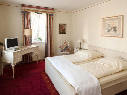 1 Schlafzimmer mit 2 Betten und einem Schreibtisch mit einem Computer in der Unterkunft Hotel Italia in Aumühle