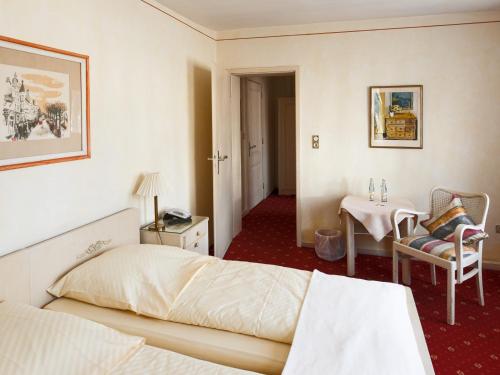 a hotel room with a bed and a table at Hotel Italia in Aumühle