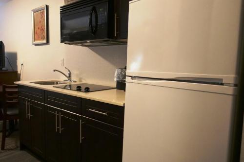 a kitchen with a white refrigerator and a sink at Ramada by Wyndham Moose Jaw in Moose Jaw