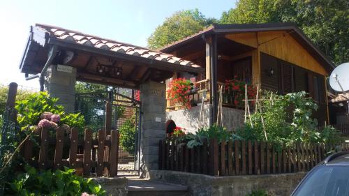 a house with a wooden fence in front of it at Baita La Stradella in Serravalle