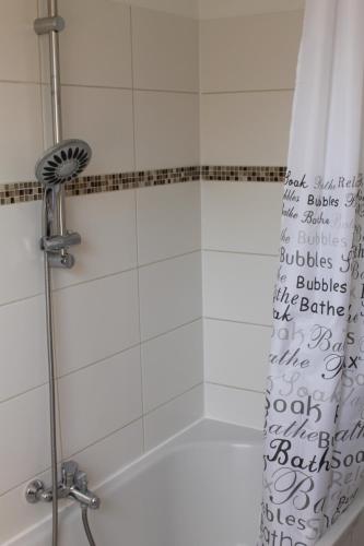 y baño con ducha y cortina de ducha. en 3 Zimmer Ferienwohnung - Woltorf, en Peine